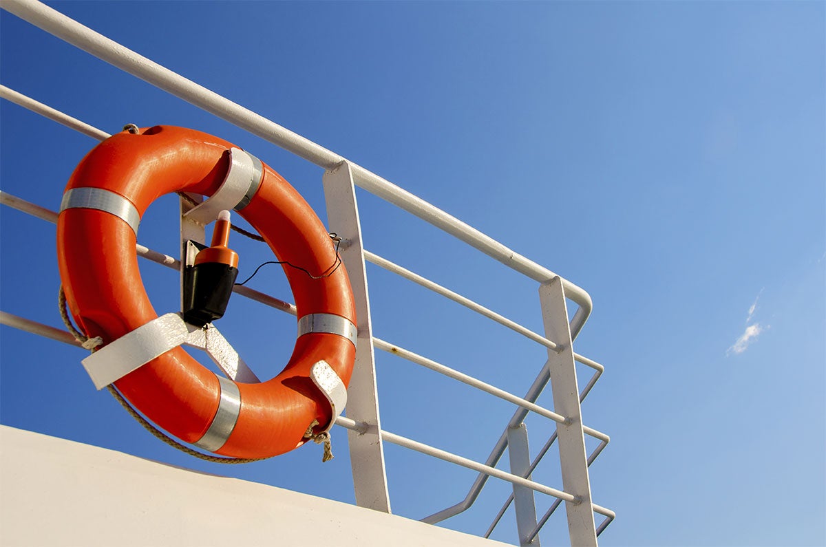 An orange life preserver on a white railing