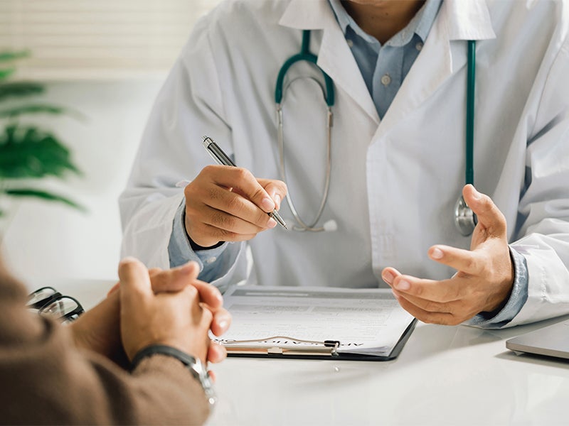 Doctor explains document to patient in office.